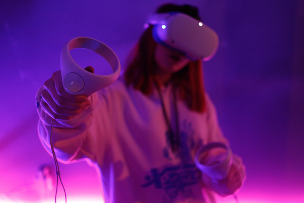 Person wearing a VR headset and holding controlers for the metaverse.
